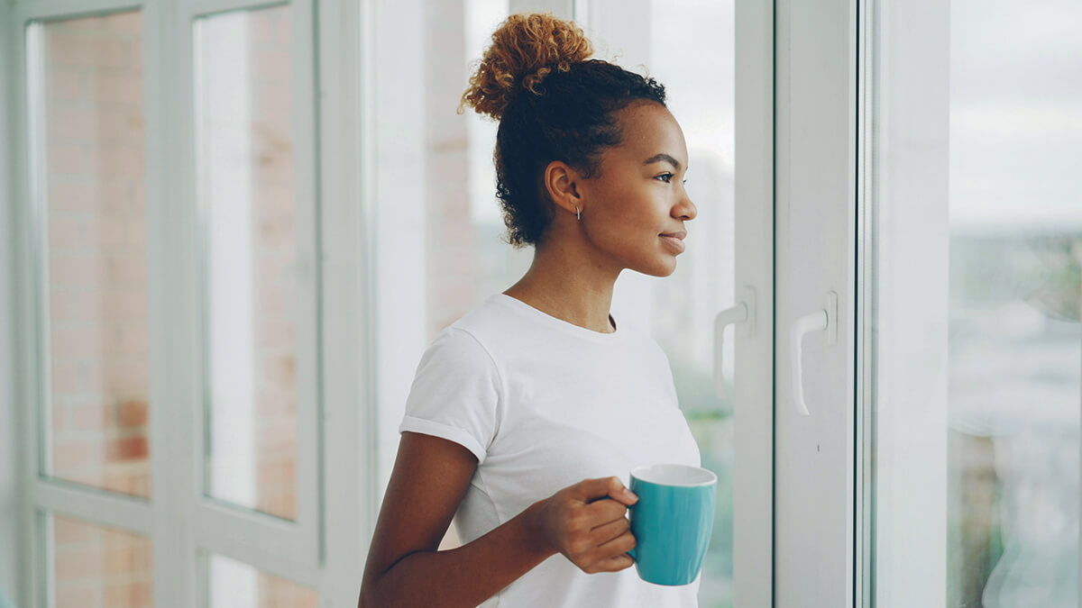 A woman looks thoughtfully out the window