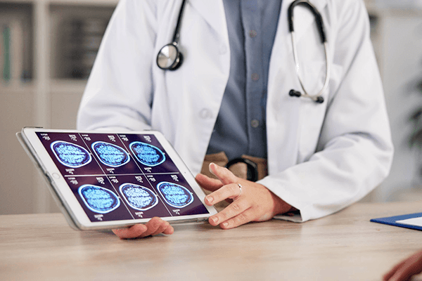 A clinician reviewing brain scan results on a tablet.