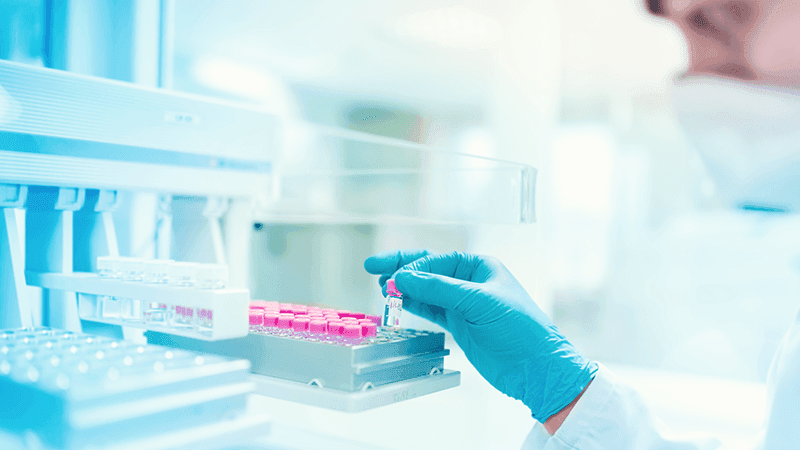 A scientist putting vials in a machine