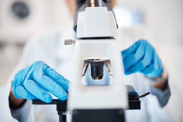 A clinician doing diagnostic tests with a microscope