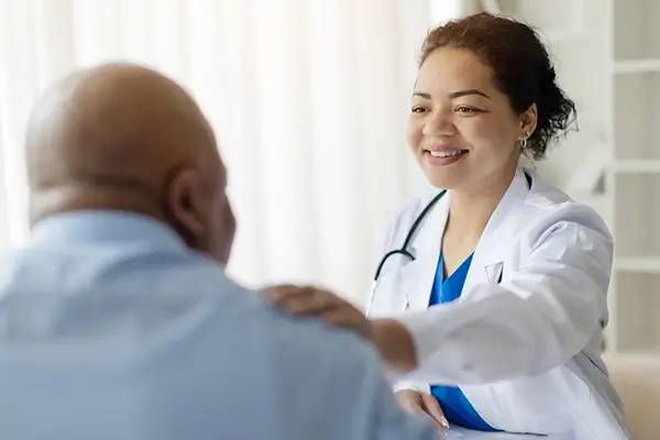 A friendly doctor placing their hand on a patients shoulder