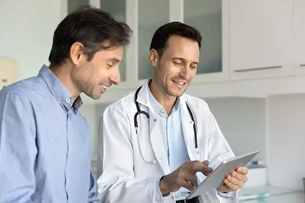 A doctor showing a patient results on a clipboard