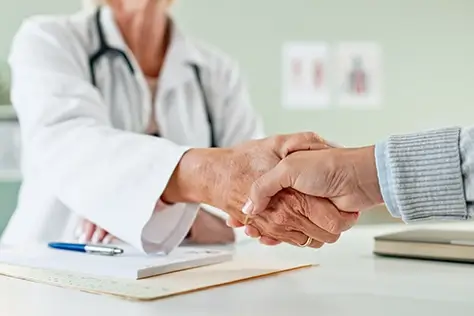 A physician shaking hands with a patient