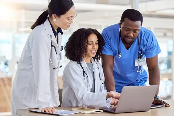 A medical team looking at a laptop together