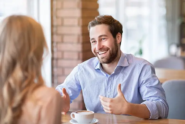 A man on a coffee date laughing and talking
