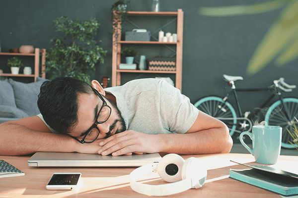 A person with chronic Lyme disease laying their head on their desk