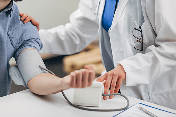 A PTSD patient getting their blood pressure taken by a physician.