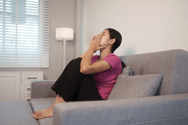 A person in their living room appearing nervous.