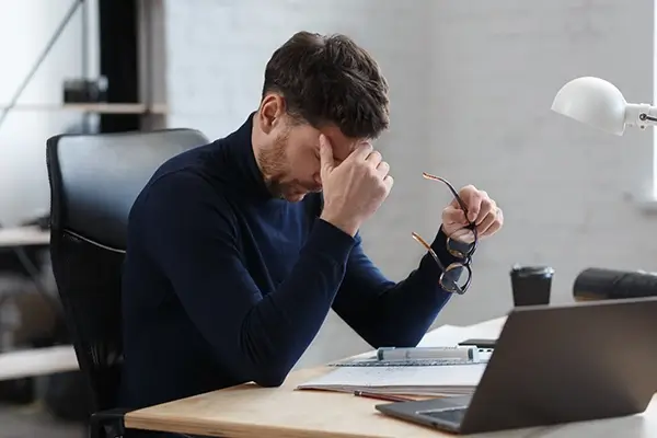 A man rubbing his head in pain.